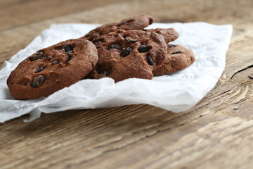 Cookies with chocolate chip on parchment paper napkin on wooden background