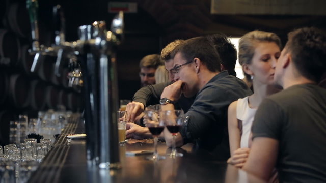 Row of people drinking at a bar
