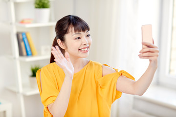 happy asian woman taking selfie with smartphone