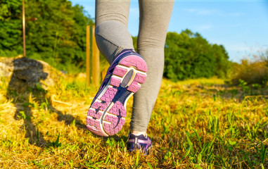 Woman running at sunset in a field
