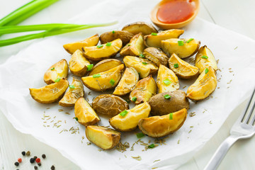 Fresh baked potato wedges on baking paper, homemade food, close-up