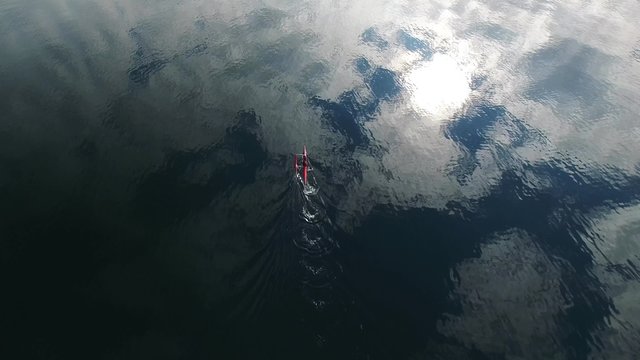 Following a sea kayaker in a mirror-like water