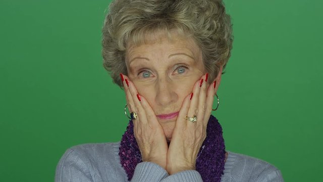 Older woman looking taken aback, on a green screen studio background