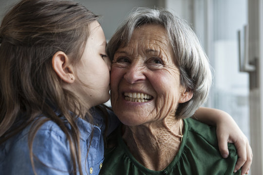Little girl kissing her grandmother