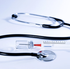 Medical equipment, stethoscope and syringe with vial on a toned background. 