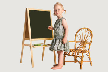 Fototapeta premium Cute girl with school black goard and marker at studio portrait with plain white background