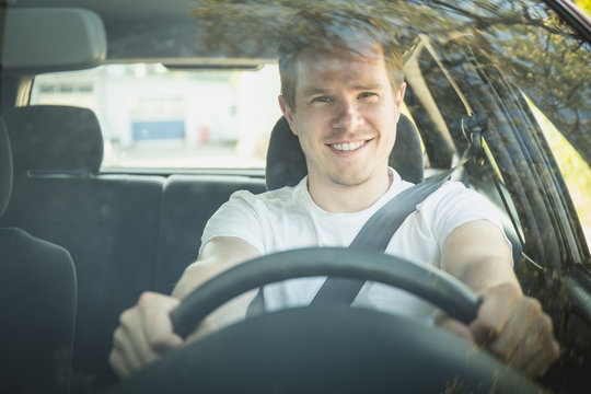 Junger Mann sitzt im Auto