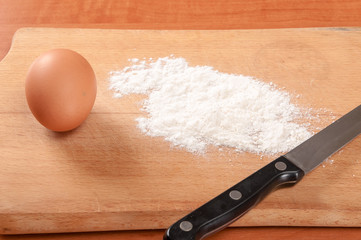 Flour and eggs on a wooden board