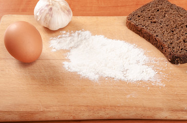 Flour and eggs on a wooden board