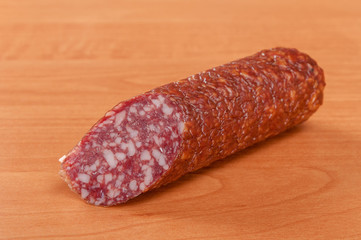 Salami for Breakfast with pepper on a wooden table