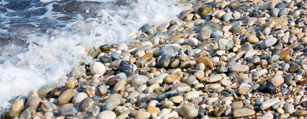 sassi biancheggianti levigati dall'acqua di mare, bagnati dalle onde dell'oceano, simbolo di erosione, rotondità e perseveranza