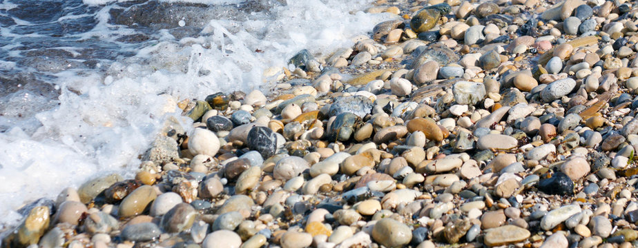 sassi biancheggianti levigati dall'acqua di mare, bagnati dalle onde dell'oceano, simbolo di erosione, rotondit&agrave; e perseveranza