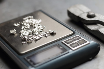 Tools of jewellery. Jewelry workplace on metal background. Weigh-scales with granules of silver.