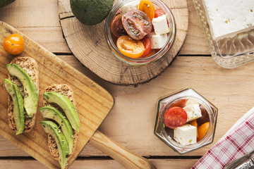 Sliced avocado on toast bread with spices and tomato salad over