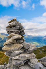 Small cairn with snow alpine mountains at background