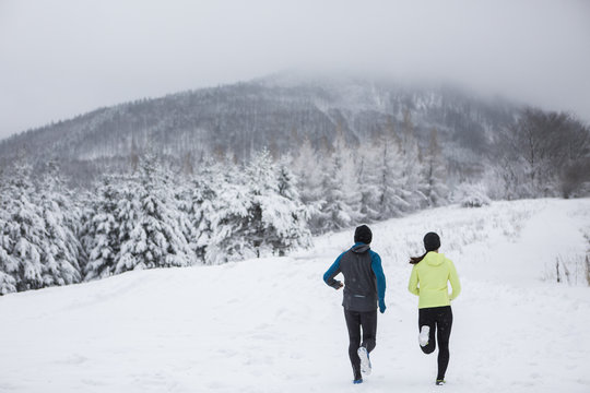Couple doing cross country run in winter