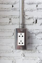 Electric plug outlet on grunge cement brick wall background.