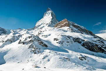 Scenic view on snowy Matterhorn peak in sunny day, Switzerland.