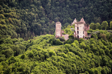 Fototapeta na wymiar Ruins of old castle in the middle of the forest hills