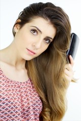 Fototapeta premium Beautiful girl brushing long wavy silky blonde hair