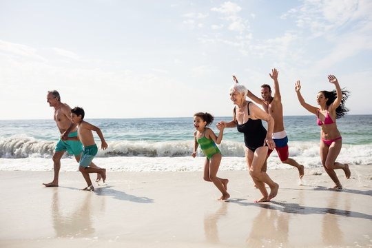 Happy family running on beach