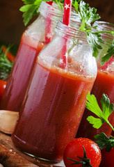 Smoothies of tomatoes and spices in glass bottles with festive r