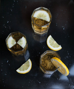 лимонад с ломтиками лимонов на черном фоне, сверху