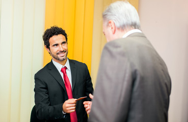 successful business executives exchanging a business card.