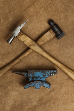 Tools of jewellery. Jewelry workplace on leather background. Hammers, anvil. Top view.