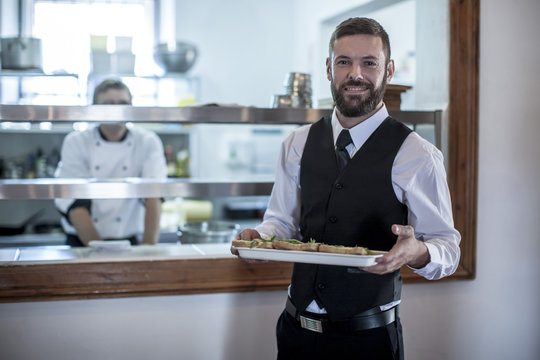 Waiter picking up food from the kitchen