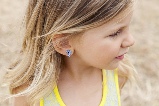 Portrait of little girl wearing a dolphin earring