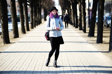 Stylish, young and beautiful girl with color hair poses on streets of St. Petersburg