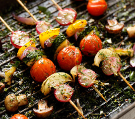 Grilled veggie skewers with cherry tomatoes, radishes, peppers and onions with fresh dill on a...
