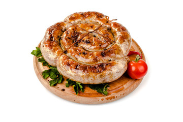 fried pork sausages on a barbecue on a wooden plate with cherry tomatoes and hot peppers