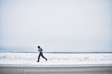 The athlete runs in the winter on the road