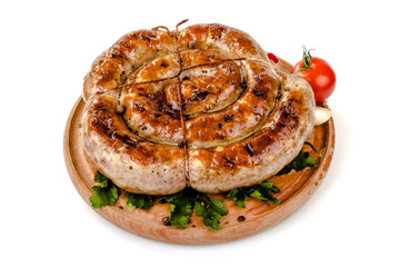 fried pork sausages on a barbecue on a wooden plate with cherry tomatoes and hot peppers