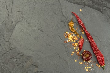 Dried chili peppers on dark slate. Strong spices for spicy foods. Decorate the kitchen. Place for your text. Creating the menu.
