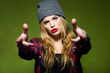 Beautiful young woman pretending to shoot gun with fingers.