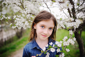 Kid girl in blooming garden