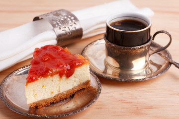 Cheesecake with goiabada jam, silver vintage cup of coffee. Selective focus