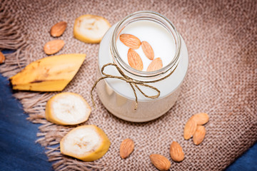 Banana and almond milk smoothie in a jar on a burlap