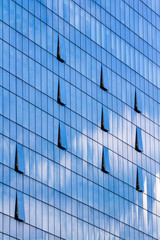 Obraz premium Facade of glass and steel with open window reflecting sky and cl