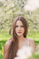 Naklejka premium Portrait of young lovely girl in spring flowers