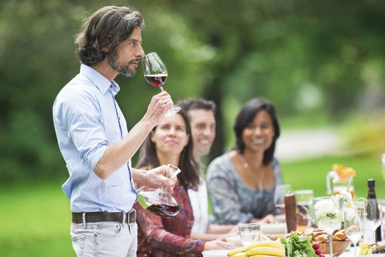 Man tasting red wine on a garden party