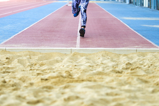 Female athlete training for long jump in stadium