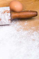baking background with pastry board, rolling pin and egg