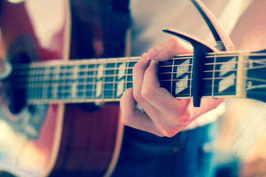 Gitarre spielen, Westerngitarre, Gitarrenhals mit Kapodaster