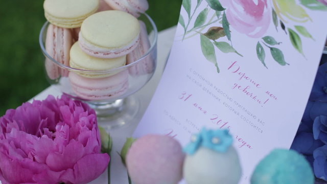 Decor sweet table. White table with sweets on nature. Wedding cakes and flowers. Sweet balls. Empty glasses with straws.