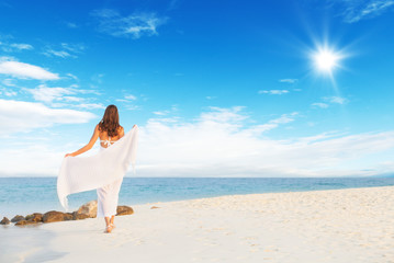 Fototapeta na wymiar Young woman walking on tropical beach