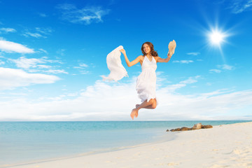 Fototapeta na wymiar Beautiful girl jumping on tropical beach